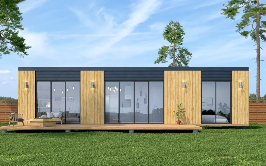 Modern single-story home with large glass windows, wooden panels, and a deck, set on a grassy lawn.